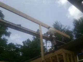 Carpenter setting a ridge beam over a new addition frame — Ice Dam Removal by Roofing Brothers in Myrtle