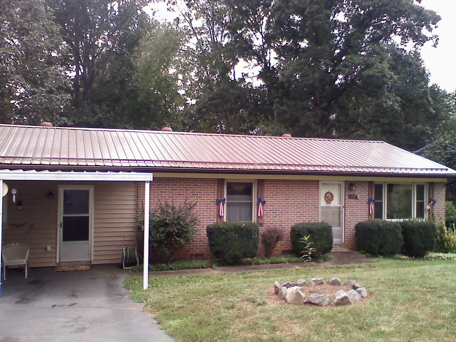 Bronze metal roof and carport on a brick ranch home — Roof Repair work by our crew in Myrtle